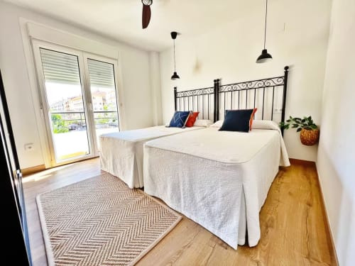 Dos camas individuales en apartamento de playa en Fuengirola, luminoso con balcón, lámparas colgantes modernas y vistas a la ciudad