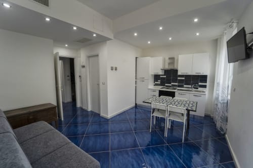 Cucina e zona pranzo moderna nell'appartamento Tramontana di Antico Palazzo del Corso con pavimento in piastrelle blu