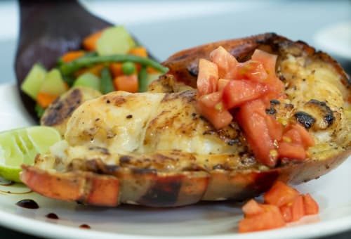 Poisson grillé garni de tomate fraîche et légumes au Belamandy Lodge, Nosy Be