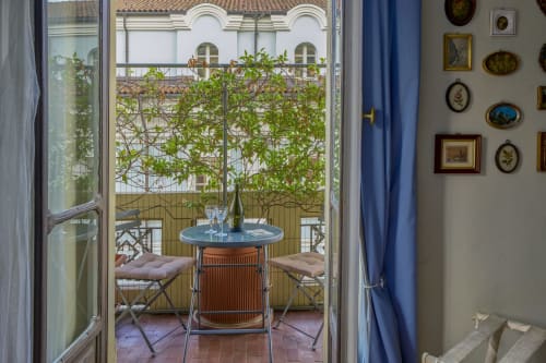 Vista dal balcone di Casa Armenia B&B Torino con pergolato ricoperto di edera, tavolo da pranzo e architettura storica