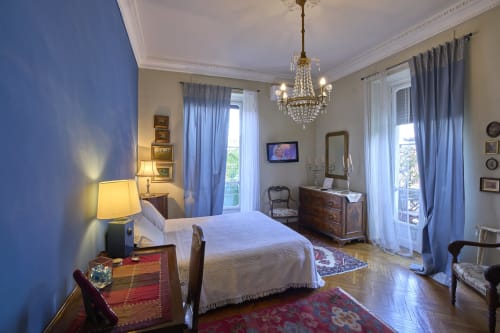 Camera elegante di A Casa Armenia B&B a Torino con lampadario in cristallo, balcone con vista sulla città e arredi classici