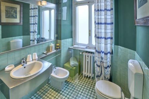 Bagno con piastrelle verdi presso la A Casa Armenia B&B di Torino con lavabo, wc, doccia e pavimento a quadri