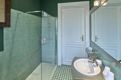 Bagno dell'A Casa Armenia B&B a Torino con doccia piastrellata verde, lavabo bianco e pavimento a scacchi