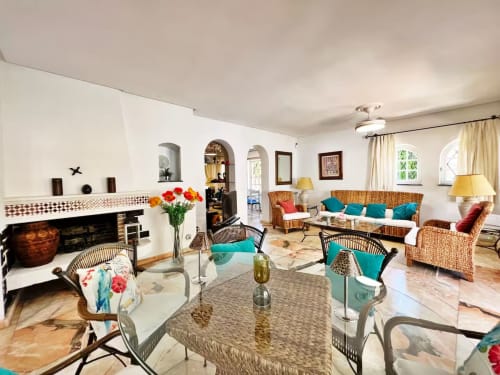 Luminoso apartamento en Fuengirola con muebles de mimbre, detalles en turquesa, chimenea y vistas al jardín