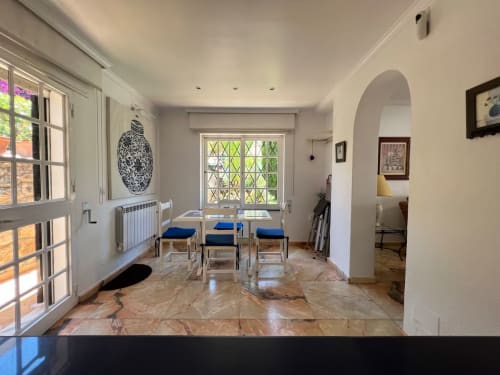 Luminoso apartamento independiente en Fuengirola con suelo de mármol, sillas de comedor y vistas al jardín a través de ventanas enrejadas