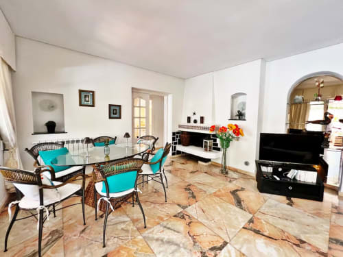 Luminoso apartamento independiente en Fuengirola con comedor, sillas turquesas, suelos de mármol y moderno espacio de estar