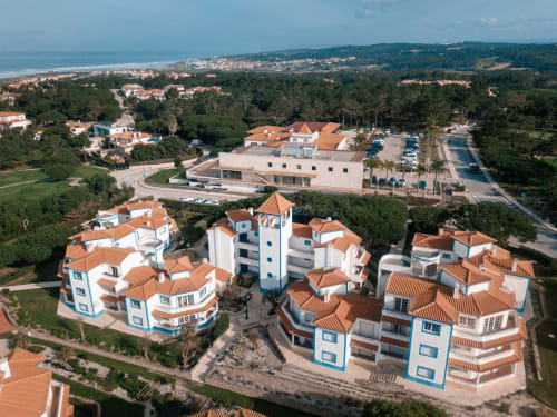 Vista aérea do hotel Be SilverCoast em Serra D'El Rei, Portugal, mostrando edifícios com telhados brancos e laranja, jardins e
