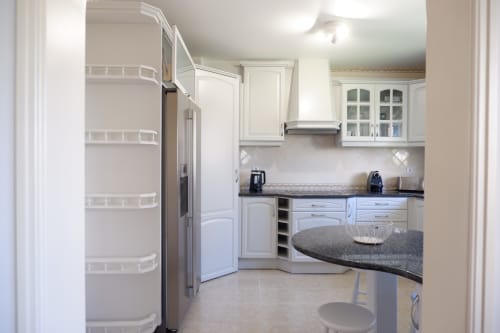 Cozinha branca moderna com eletrodomésticos em aço inoxidável e bancadas em granito no hotel Be SilverCoast, Serra D'El Rei