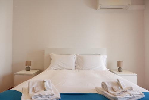 Quarto moderno e limpo no hotel Be SilverCoast em Serra D'El Rei, com roupa de cama branca, mesas laterais e luminárias