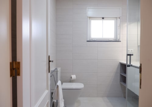 Banheiro moderno em Casa Lusitania no hotel Be SilverCoast, Serra d'El Rei, Portugal, com azulejos brancos e sanitários