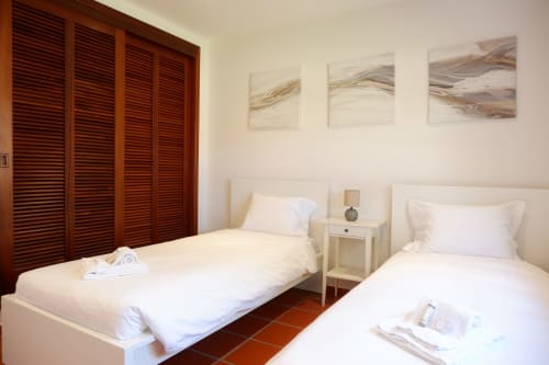 Quarto twin com camas brancas, persianas de madeira e arte abstrata na parede no hotel Be SilverCoast em Serra D'El Rei, Portugal