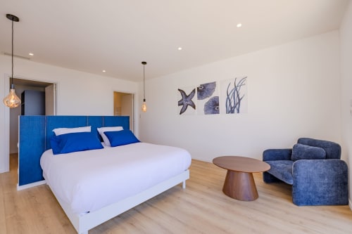 Chambre moderne à la villa PERLE D'AZUR avec tête de lit bleue, linge blanc, suspensions, décor avec vue mer et coin détente
