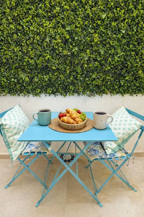 Desayuno en apartamento frente al mar en Fuengirola con mesa azul, sillas, cruasanes, frutas frescas y café