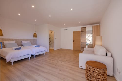 Suite moderne à la Villa Prestige Azur Antilles avec lits jumeaux, coin salon, parquet et salle de bain attenante