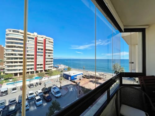 Vista del balcón de apartamento frente al mar en Fuengirola con vistas al océano, playa y edificios costeros