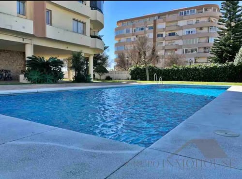 Piscina frente al mar del complejo Grupo Inmo House en Fuengirola con vistas al mar, rodeada de edificios modernos y jardines