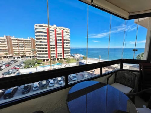 Apartamento frente al mar en Fuengirola con vistas panorámicas al mar, mobiliario moderno y entorno de resort costero.