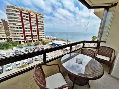 Balcón de apartamento frente al mar en Fuengirola con vistas al océano, muebles de mimbre y costa mediterránea
