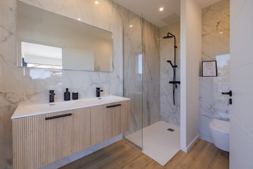 Salle de bain moderne en marbre de la villa PERLE D'AZUR chez Villa Prestige Azur Antilles avec double vasque, douche à l'italienne et toilettes