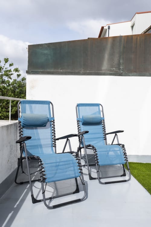 Two blue reclining chairs on a sunny terrace at RH Charming Apartments in Braga, Portugal