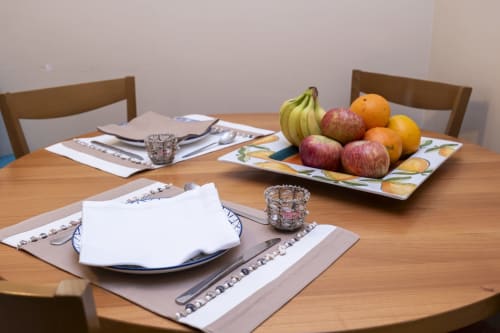 Elegant dining table at RH Charming Apartment with place settings, fresh fruit bowl, and wine glasses