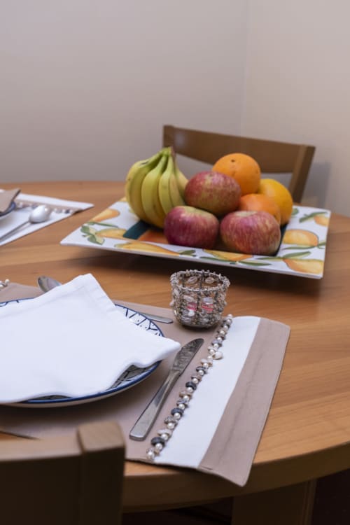 Elegant dining setup at RH Charming Apartments with fresh fruits, place settings, and decorative accents on wooden table