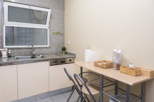 Modern kitchenette in RH Charming Apartment São Victor, Braga with stainless steel appliances and dining area