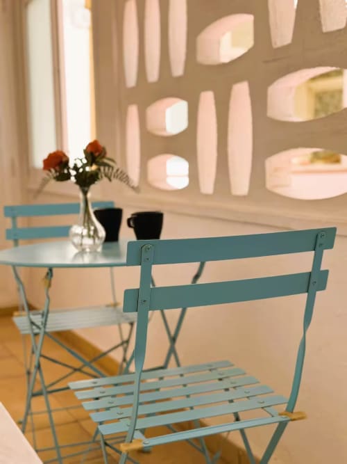 Sillas turquesas en mesa de comedor con flores frescas en apartamento de Fuengirola, diseño interior moderno