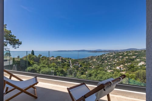 Balcon de la villa Perle d'Azur avec chaises longues surplombant la Méditerranée et les jardins luxuriants de Villa Prestige Azur Antilles