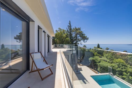 Terrasse de la villa Perle d'Azur avec vue mer, transat, piscine chauffée d'eau salée et paysage méditerranéen