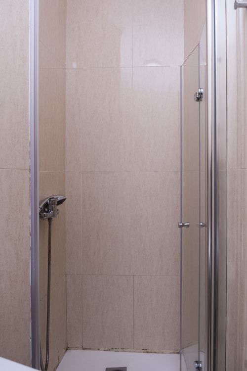 Modern bathroom shower enclosure with beige tiled walls and chrome fixtures at RH Charming Apartments, Barcelos