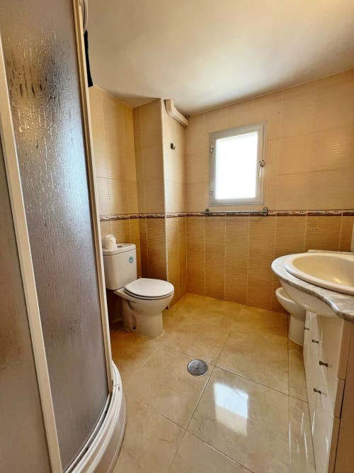 Cuarto de baño moderno con ducha, inodoro y tocador en apartamento frente al mar, Fuengirola