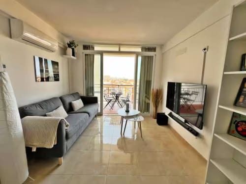 Moderno apartamento frente al mar en Fuengirola con vistas a la ciudad, sofá gris, acceso a balcón y mobiliario contemporáneo