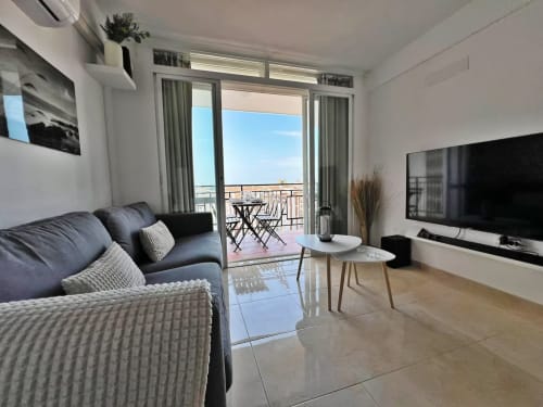 Moderno apartamento de playa en Fuengirola con vistas al mar, salón amueblado, balcón y ventanales de piso a techo