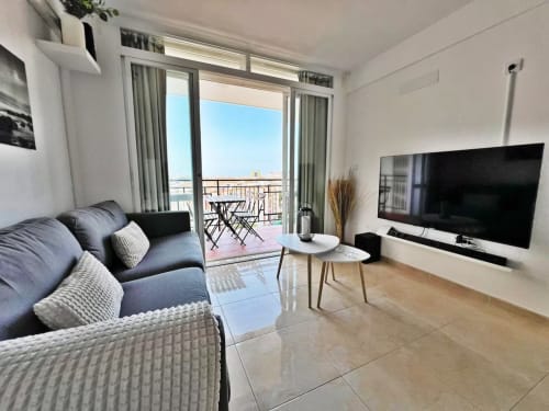 Moderno apartamento en primera línea de playa en Fuengirola con vistas a la ciudad, salón diáfano, televisor de pantalla plana y balcón con vista al mar