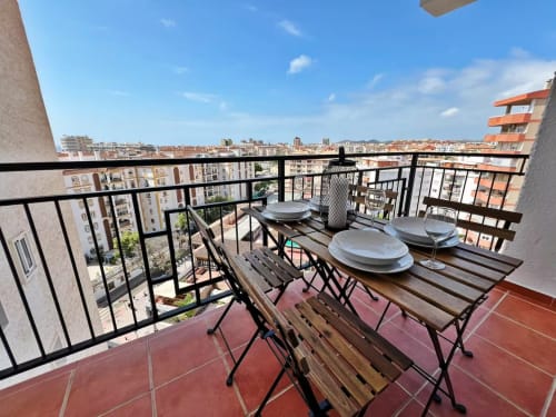 Balcón de rascacielos con mesa de comedor con vistas a Fuengirola y el Mediterráneo