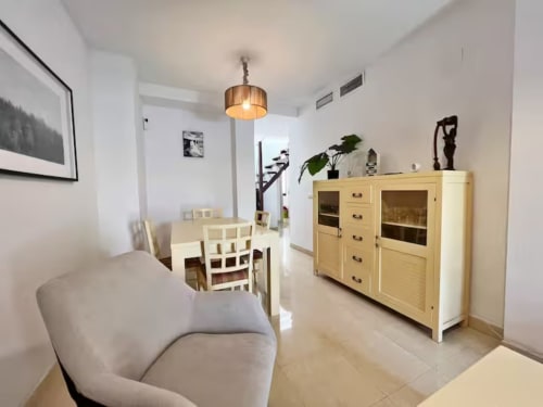 Comedor de apartamento en playa de Fuengirola con muebles de madera clara y diseño contemporáneo