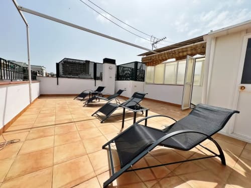 Terraza en azotea de apartamento frente al mar en Fuengirola con tumbonas y vistas a la ciudad