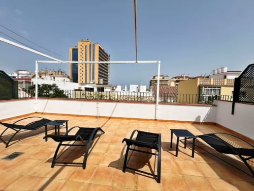 Terraza de azotea con tumbonas con vistas al skyline de Fuengirola, apartamento exclusivo en primera línea de playa