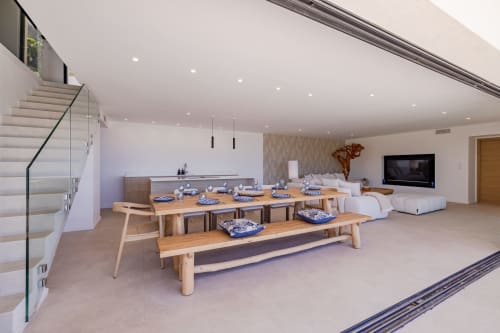 Espace ouvert salle à manger et séjour de la villa Perle d'Azur avec tables en bois, cuisine moderne et coin salon vue mer