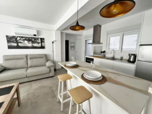 Moderno apartamento de lujo en la playa de Fuengirola con cocina abierta, comedor y salón con iluminación colgante