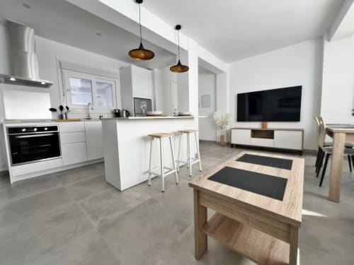 Moderno apartamento de lujo frente al mar en Fuengirola con cocina abierta, comedor y sala con televisor de pantalla plana