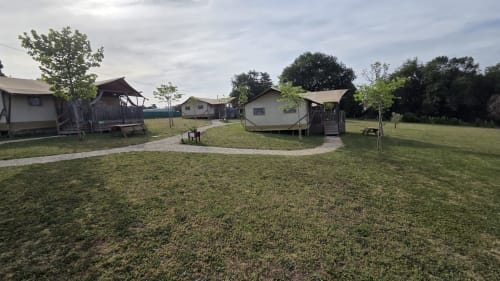 Glamping pods van Home Sweet Lodge in Saint Germain et Mons, Aquitaine, met groene grasvelden en wandelpaden