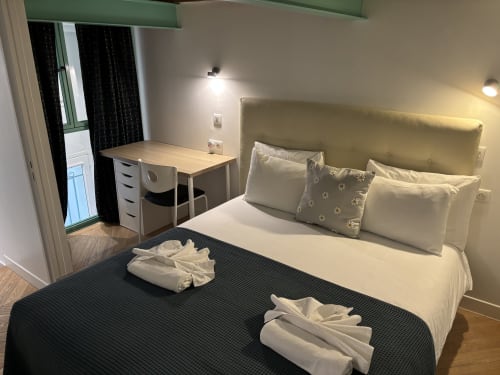 Modern Parisian apartment bedroom with queen bed, work desk, and contemporary furnishings near Pompidou Center