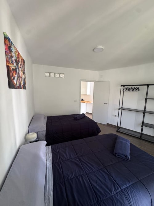 Dormitorio luminoso con dos camas, ropa de cama negra y comodidades modernas del apartamento Torre Sol Y Playa en Torremolinos