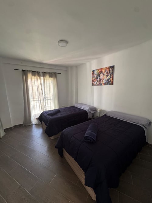 Habitación luminosa con dos camas, acceso a balcón con vistas al mar y comodidades modernas en Torre Sol Y Playa, Torremolinos