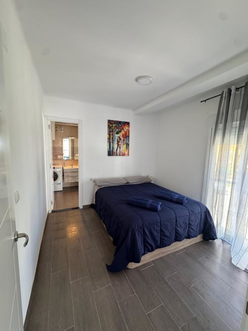 Dormitorio moderno del apartamento Torre Sol Y Playa en Torremolinos, con vistas al mar y ropa de cama azul oscuro