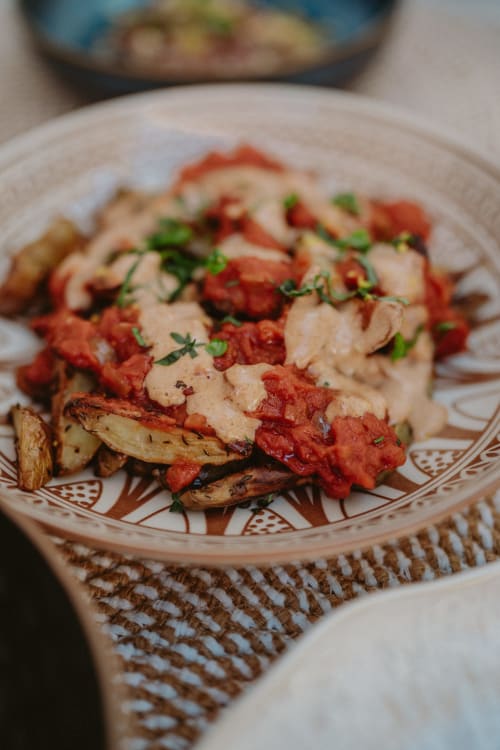 Assiette au Bleu Guesthouse à Saint François : protéine saisie, sauce rouge et herbes fraîches sur légumes rôtis