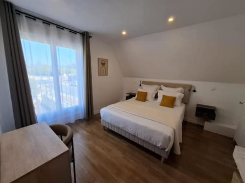 Deluxe double bedroom at La Villa Cassinne with balcony, garden views, and parquet flooring in Montebourg