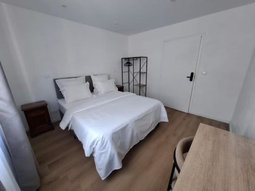 Bright, accessible king-size bedroom at La Villa Cassinne in Montebourg with white bedding, wooden desk, and modern